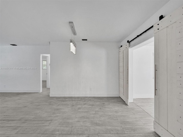 empty room featuring light hardwood / wood-style flooring and a barn door