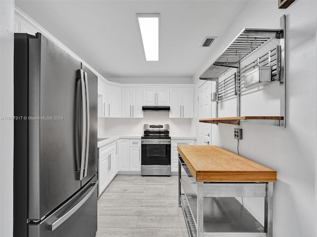 kitchen with appliances with stainless steel finishes, white cabinetry, and light hardwood / wood-style floors