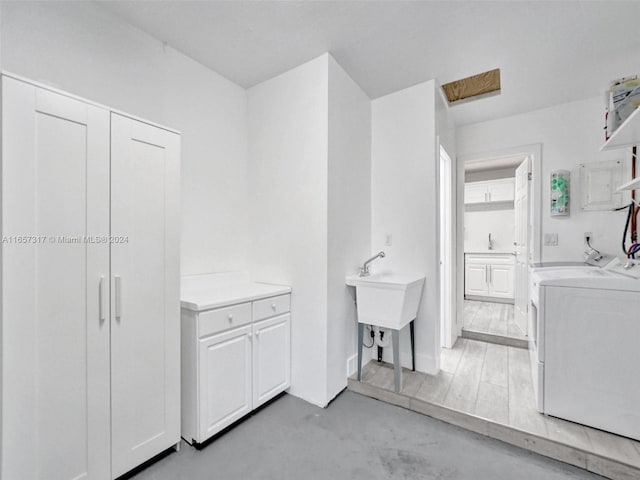 laundry area with independent washer and dryer and light wood-type flooring