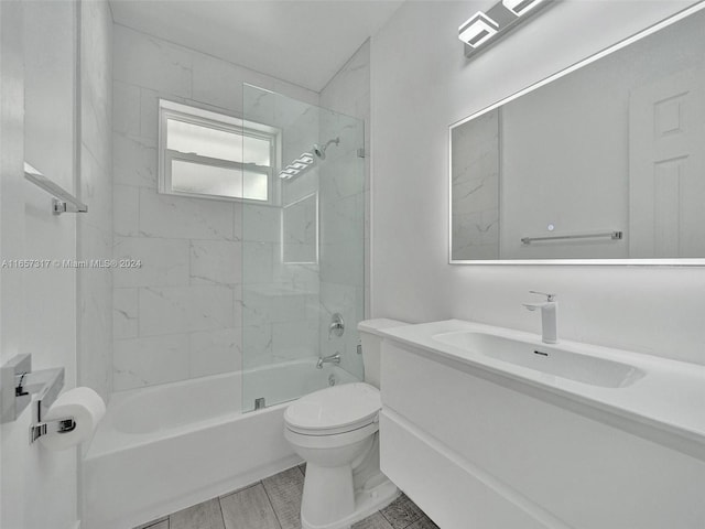 full bathroom with tiled shower / bath, vanity, and toilet