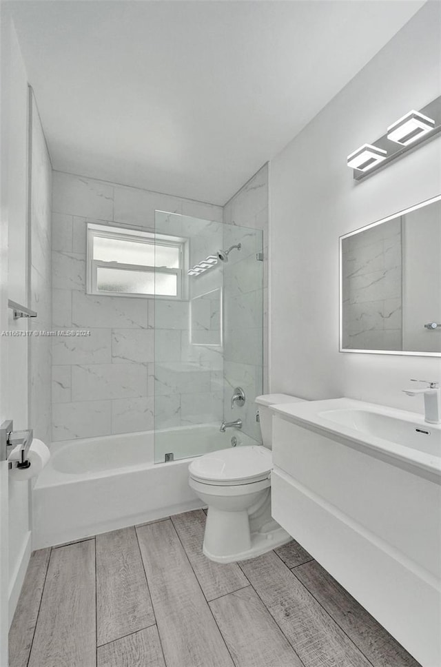 full bathroom featuring vanity, toilet, and tiled shower / bath combo