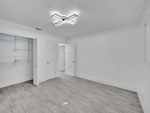 unfurnished bedroom featuring light wood-type flooring and a closet