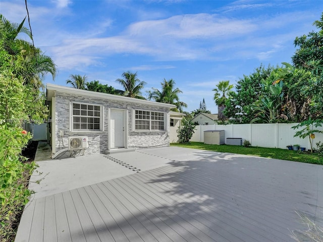 rear view of house with ac unit and a deck