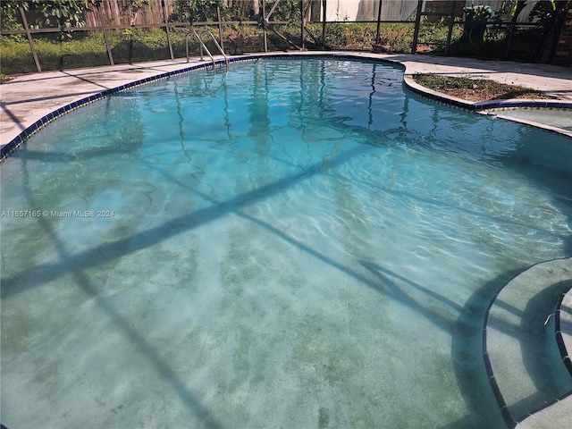 view of swimming pool with glass enclosure