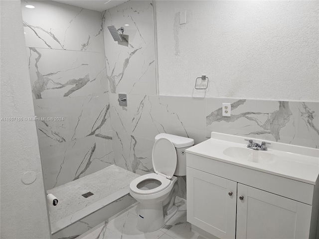 bathroom with tiled shower, tile walls, vanity, and toilet