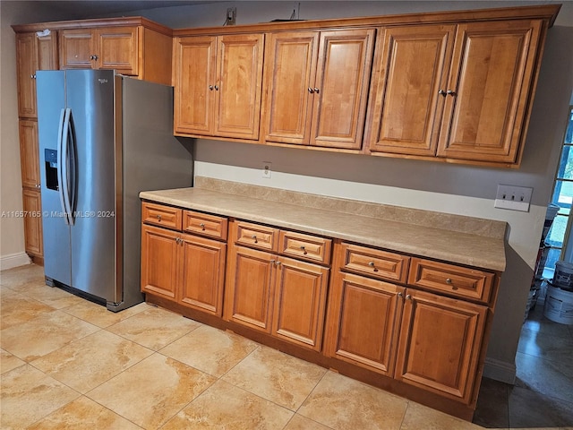 kitchen featuring light tile patterned floors and stainless steel fridge with ice dispenser