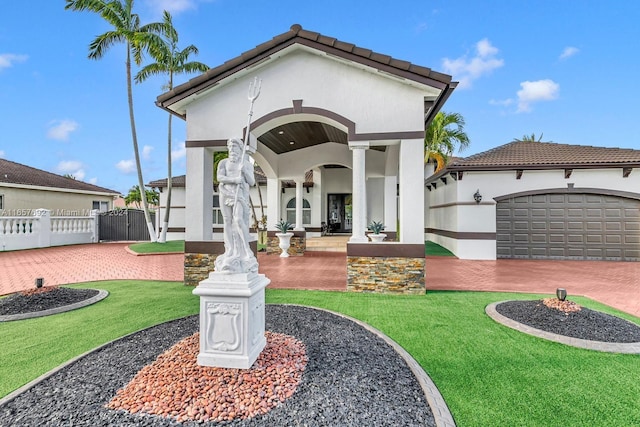 mediterranean / spanish-style house featuring a garage and a front yard