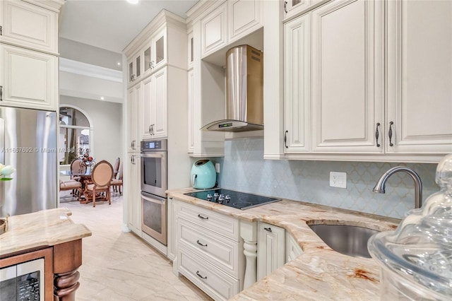 kitchen featuring appliances with stainless steel finishes, wall chimney exhaust hood, light stone counters, and white cabinets