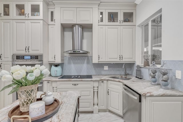 kitchen featuring stainless steel appliances, wall chimney exhaust hood, sink, and white cabinetry