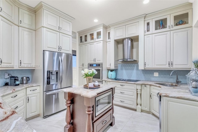 kitchen featuring sink, wall chimney exhaust hood, stainless steel appliances, and white cabinetry