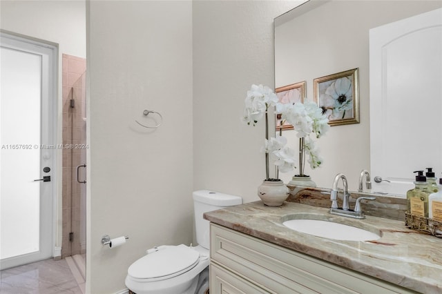 bathroom with vanity, toilet, and a shower with door