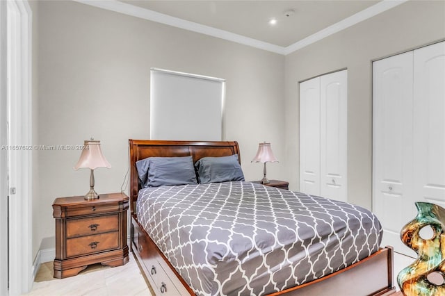 bedroom with ornamental molding and multiple closets