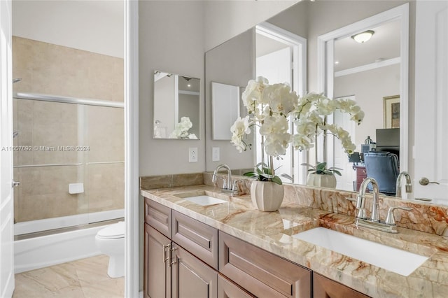 full bathroom featuring enclosed tub / shower combo, crown molding, vanity, and toilet