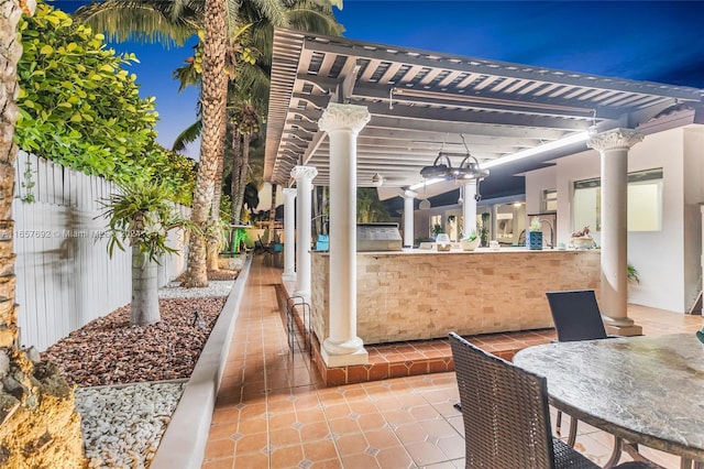 view of patio with area for grilling, a pergola, and a bar