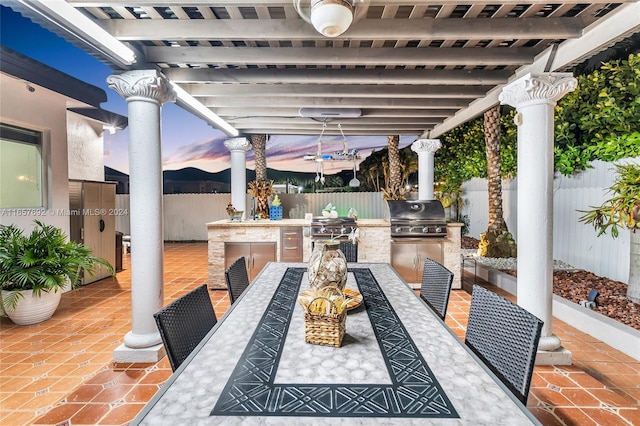 patio terrace at dusk featuring a pergola, area for grilling, and grilling area