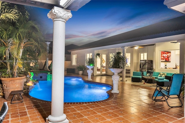 pool at dusk featuring ceiling fan and ornate columns