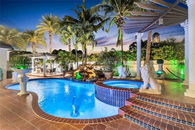 pool at dusk featuring a patio, a pergola, and an in ground hot tub