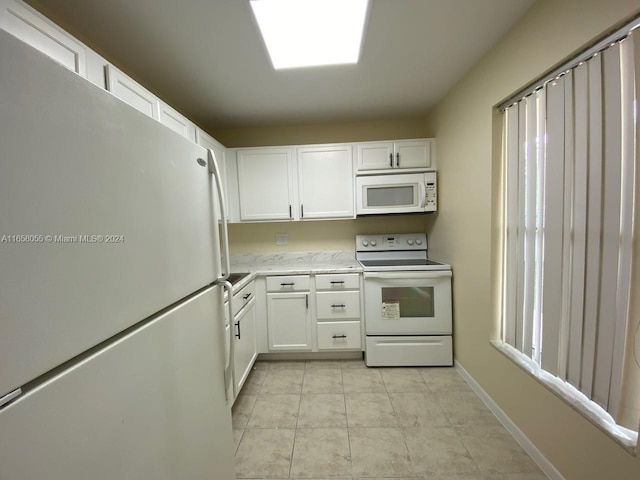 kitchen featuring white appliances and white cabinetry