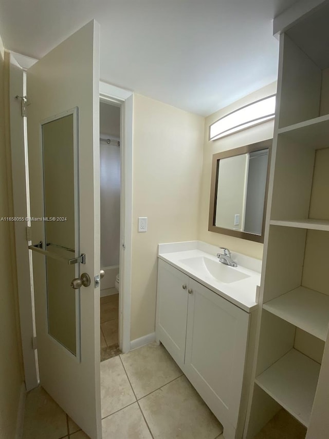 bathroom with vanity, toilet, and tile patterned flooring