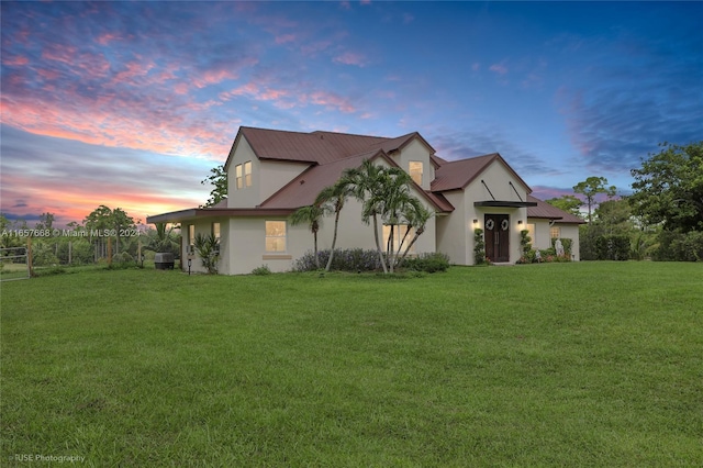 property exterior at dusk featuring a yard