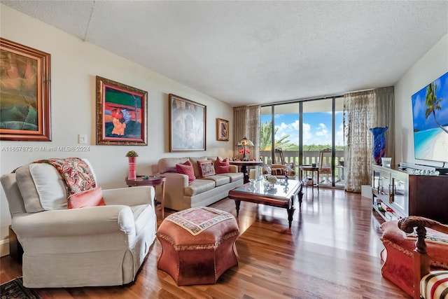 living room with a textured ceiling, hardwood / wood-style floors, and expansive windows