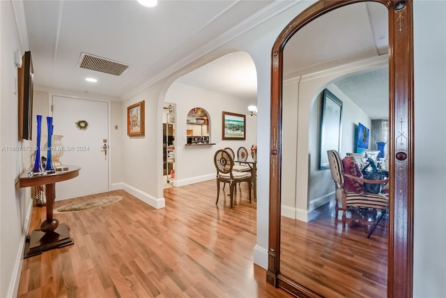 entrance foyer with ornamental molding and hardwood / wood-style flooring