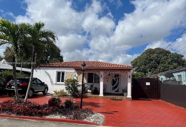 mediterranean / spanish home featuring covered porch