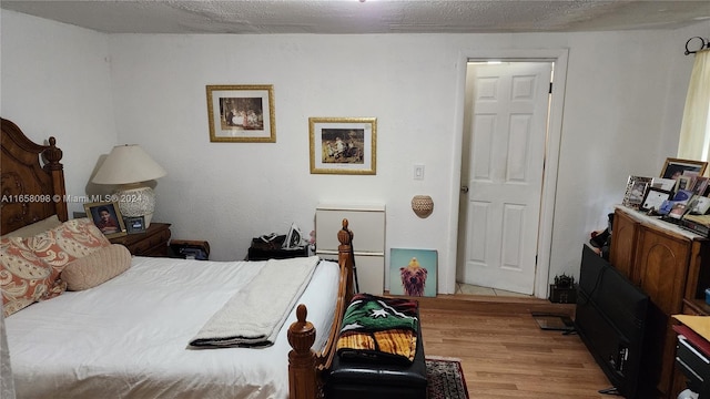 bedroom featuring light wood-type flooring and a textured ceiling