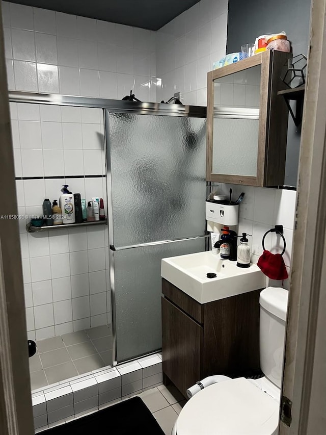 bathroom featuring vanity, toilet, an enclosed shower, and tile patterned floors