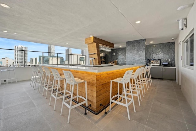 kitchen with light tile patterned floors, decorative backsplash, and a kitchen breakfast bar