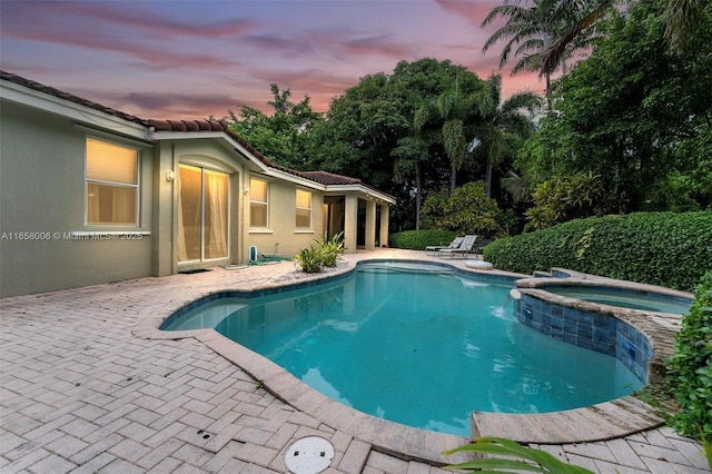 view of pool featuring a pool with connected hot tub and a patio area