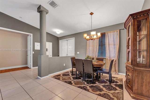 dining area with visible vents, baseboards, decorative columns, vaulted ceiling, and light tile patterned flooring