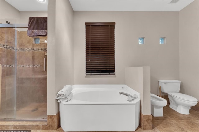 full bathroom featuring a stall shower, toilet, a bidet, and a garden tub