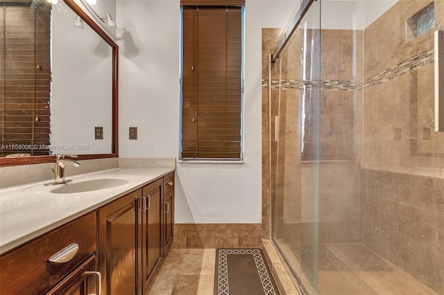 bathroom featuring a tile shower and vanity