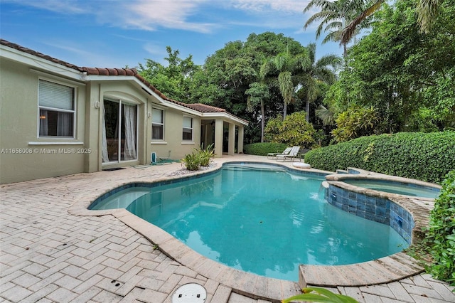 view of swimming pool featuring an in ground hot tub and a patio area