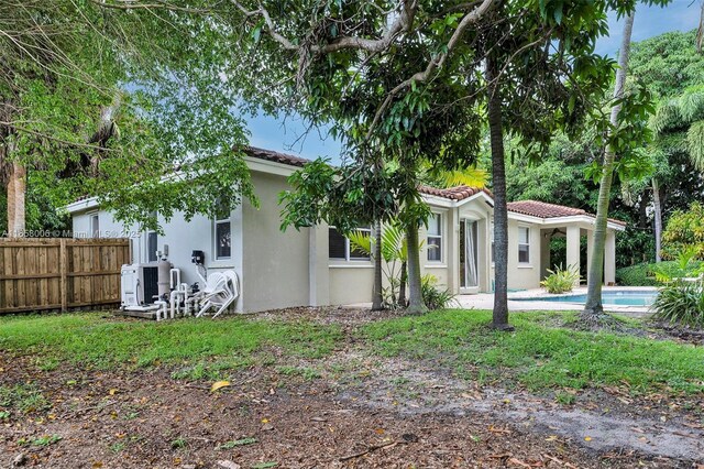 view of front of home with a fenced in pool and central AC