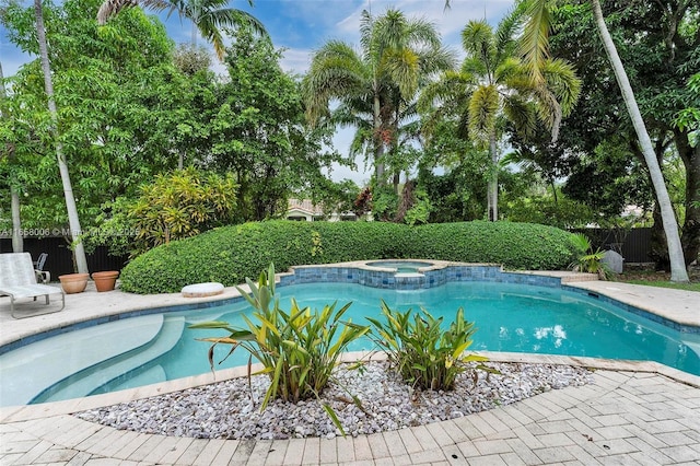 view of swimming pool featuring a patio, fence, and a pool with connected hot tub