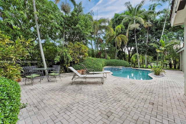 view of pool featuring outdoor dining area, a patio area, and a pool with connected hot tub