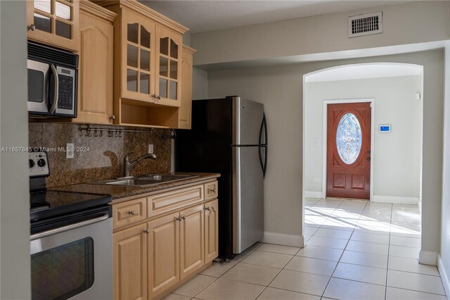 kitchen featuring light brown cabinetry, backsplash, stainless steel appliances, sink, and light tile patterned floors