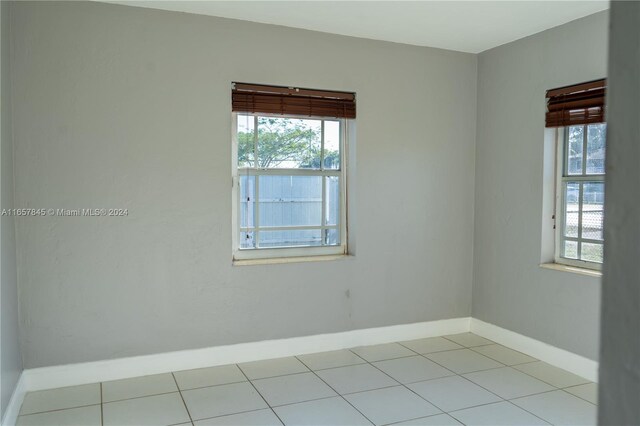 spare room with light tile patterned floors and a healthy amount of sunlight