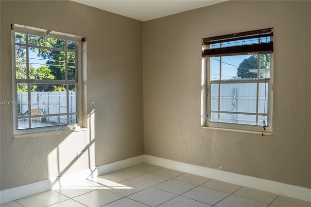 tiled empty room featuring plenty of natural light