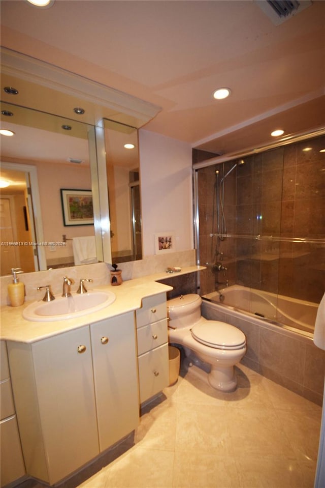 full bathroom with tiled shower / bath, vanity, toilet, and tile patterned floors