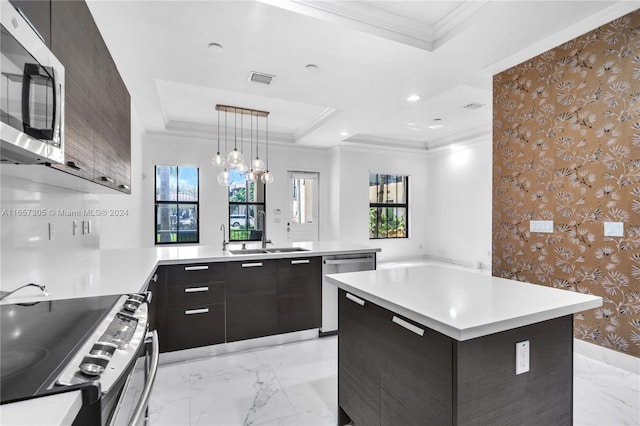 kitchen with a kitchen island, stainless steel appliances, sink, kitchen peninsula, and decorative light fixtures