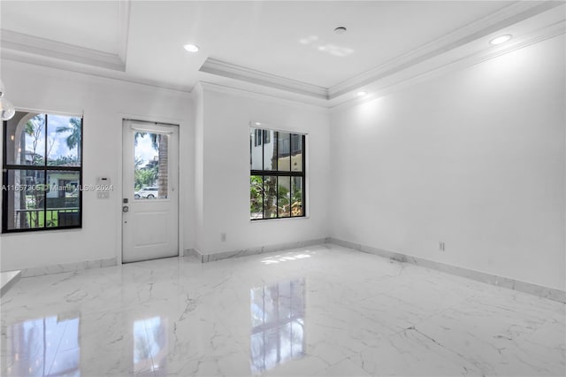 foyer featuring a raised ceiling and crown molding