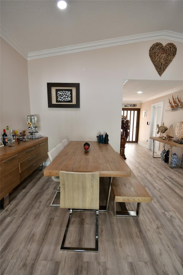dining area featuring ornamental molding, baseboards, and wood finished floors