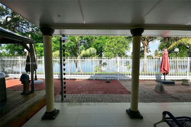 view of patio / terrace with a water view and fence