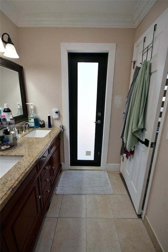 full bath featuring tile patterned floors, crown molding, a sink, and double vanity
