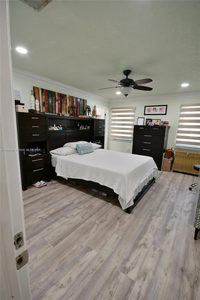 bedroom featuring a ceiling fan, recessed lighting, ornamental molding, light wood finished floors, and visible vents