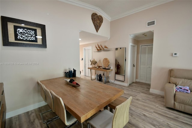 dining space with crown molding, baseboards, visible vents, and wood finished floors