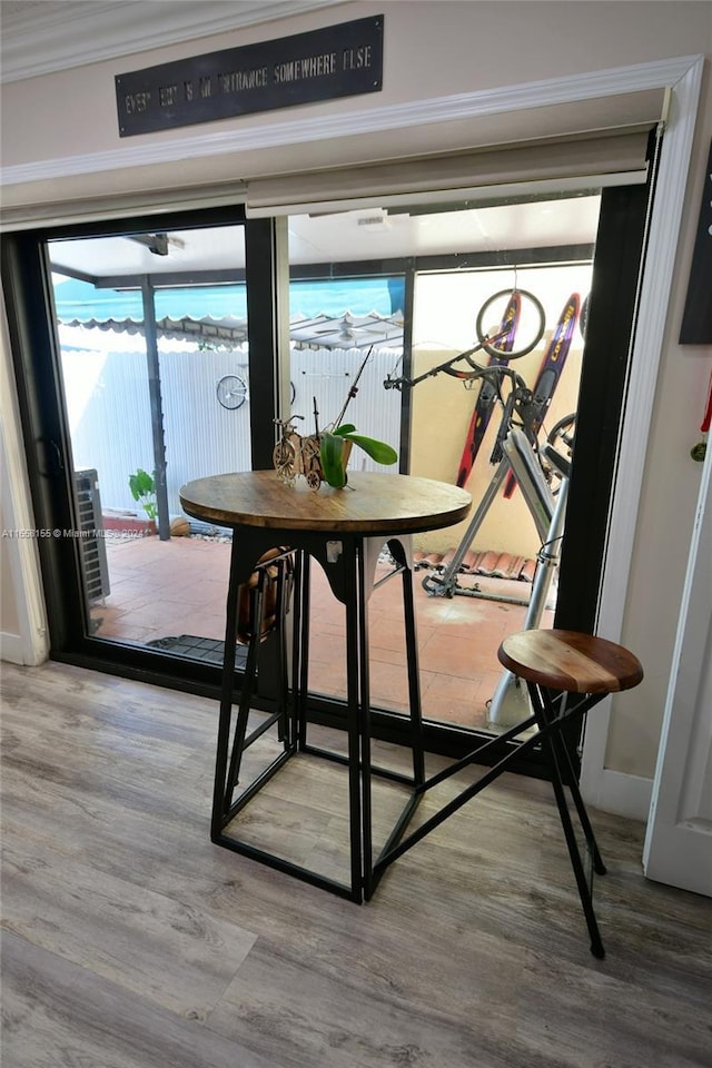 dining area with crown molding and wood finished floors